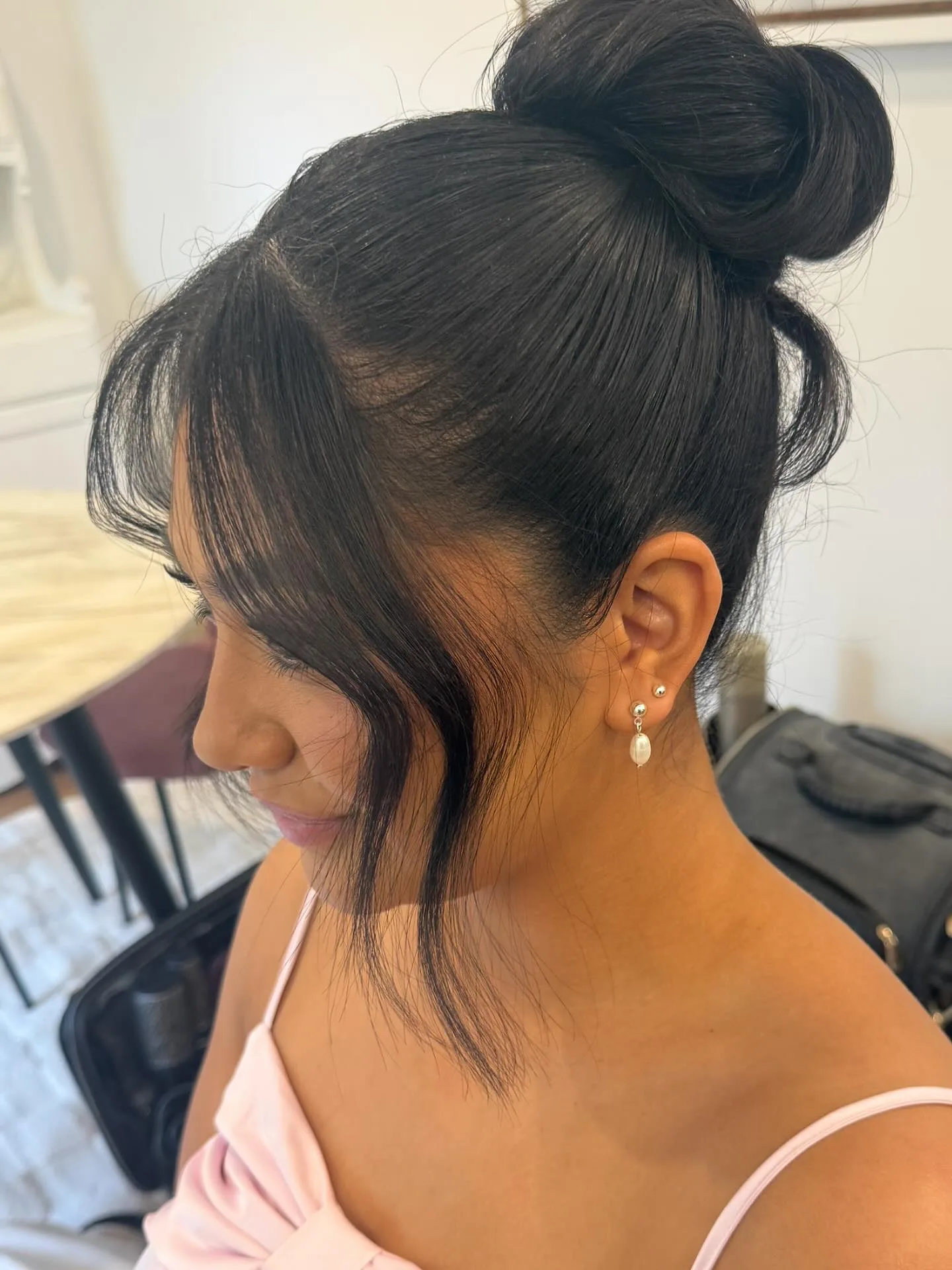 Dark high sculpted updo bun, event styling, face downcast
